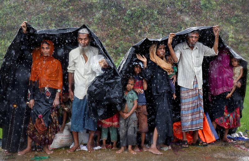 Rohingya refugees take shelter from the rain in a camp in Cox's Bazar, Bangladesh. Cathal McNaughton / Reuters