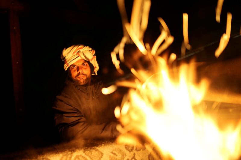 A migrant warms up at the camp. Reuters