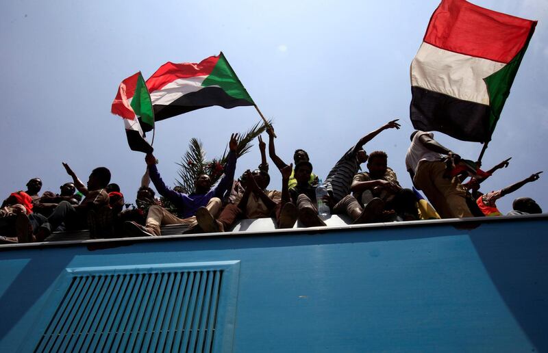 Sudanese civilians wave their national flags as they ride on the train to join in the celebrations of the signing of the Sudan's power sharing deal. REUTERS/Mohamed Nureldin Abdallah