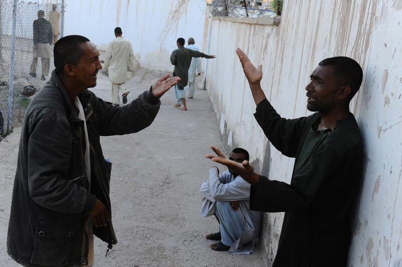Afghan patients argue with one another outside in the yard.