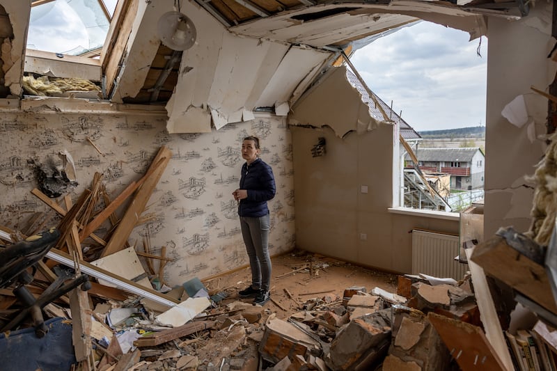 Oksana searches for salvageable items on the destroyed second floor of her home in Hostomel, April 2022. Getty Images
