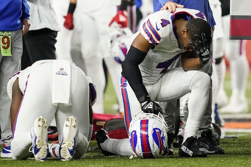 Buffalo Bills players and staff pray for Damar Hamlin during the first half of an NFL football game against the Cincinnati Bengals. AP