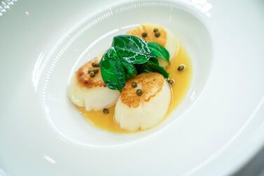 The pan-fried scallops served with lemon supreme confit with butter and fresh baby spinach. Courtesy Rue Royale / Anton Pole