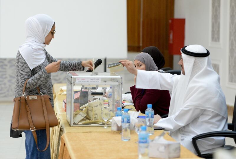 A Kuwaiti woman casts her ballot at a polling station during the parliament by-election in Kuwait city, Kuwait.  EPA