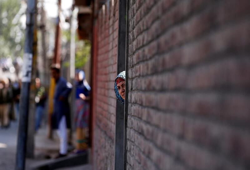 A woman looks out from a door during a protest against the recent killings in Kashmir region in Srinagar.  Danish Ismail / Reuters