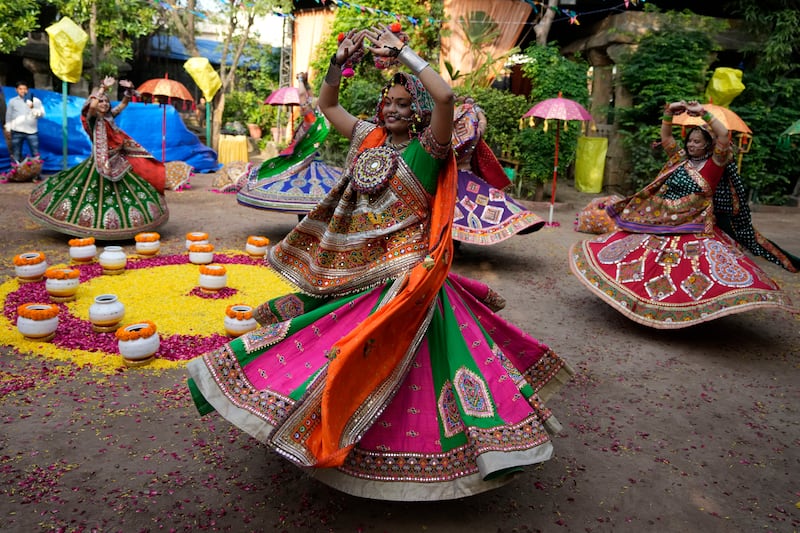 Women wearing traditional attire twirl as part of the garba, in which participants dance around in circles. AP