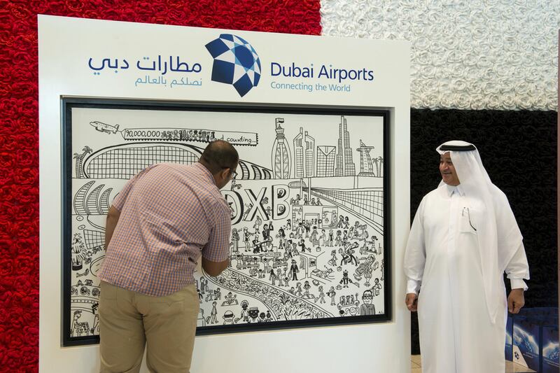 Abdullah Lutfi putting finishing touches to a commissioned painting on Dubai Airports as his father watches. Courtesy: Susanna Dahlstedt