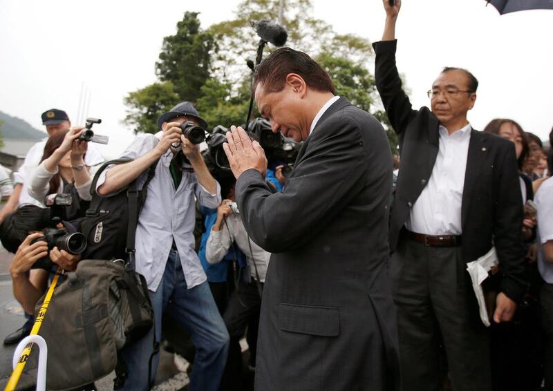 Governor of Japan’s Kanagawa prefecture Yuji Kuroiwa, centre, prays as he visits the facility. Issei Kato / Reuters