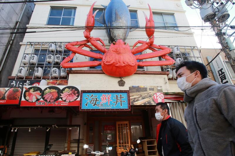 People walk past Tsukiji Outer Market in Tokyo, Japan. AP Photo