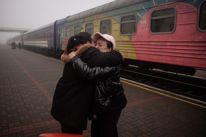Friends hug after the arrival of a train in the southern city of Kherson. Getty