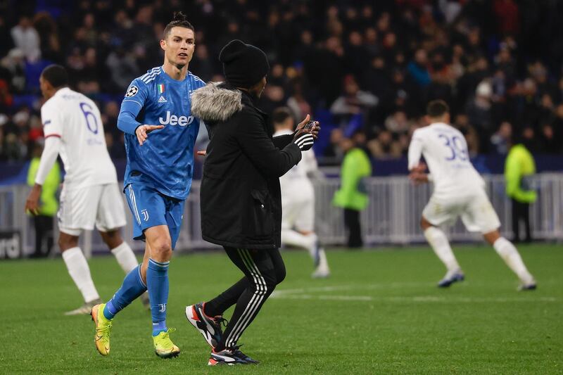 Cristiano Ronaldo of Juventus with a pitch invader in Lyon. EPA