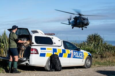In this photo provided by the New Zealand Defence Force, a police officer watches as a helicopter takes off during a rescue operation to find two missing trampers in the Kahurangi National Park in the South Island of New Zealand, Wednesday, May 27, 2020. Two hikers rescued in the New Zealand wilderness Wednesday got lost in fog and exhausted their food but survived 19 days with only minor injuries, police said. (CPL Naomi James/New Zealand Defence Force via AP)