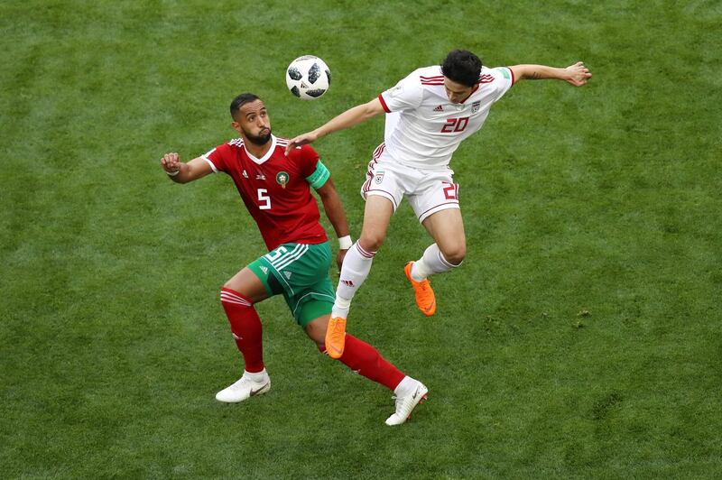 SAINT PETERSBURG, RUSSIA - JUNE 15:  Sardar Azmoun of Iran wins a header from Mehdi Benatia of Morocco during the 2018 FIFA World Cup Russia group B match between Morocco and Iran at Saint Petersburg Stadium on June 15, 2018 in Saint Petersburg, Russia.  (Photo by Francois Nel/Getty Images)