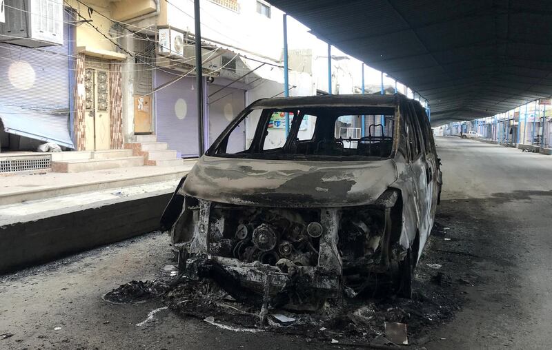 A burnt car is seen along a deserted street in the town of Ras Al Ain. Reuters