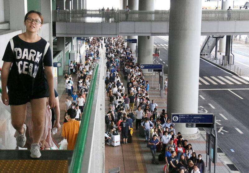 Stranded passengers queue up in lines to wait for special buses at Kansai International Airport following a powerful typhoon in Osaka, western Japan. AP Photo