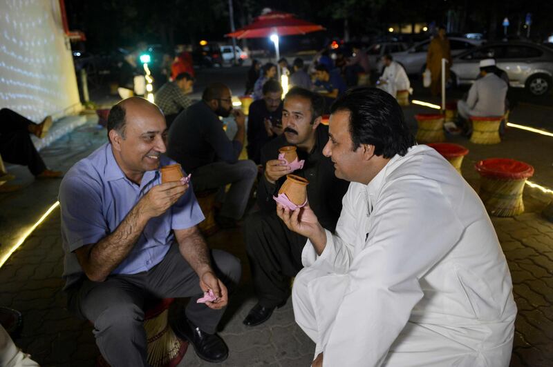 Pakistani people gather to drink tandoori tea in clay pots at a market in Islamabad. It's a cuppa like no other. Every evening in Islamabad a crowd arrives at Sanaullah's street stall to taste his "tandoori chai" - milk tea served in terracotta mugs, still hot from his traditional oven. The old-fashioned cups are placed directly inside the tandoor, where they are baked at high temperatures. Photo: AFP