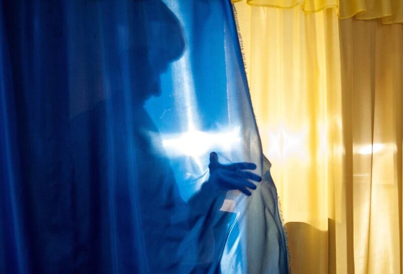 A local resident casts a shadow leaving a booth to cast her ballot at a polling station in Luhansk, Ukraine. Residents of two restive regions in eastern Ukraine cast ballots Sunday in referendums, which seek approval for declaring sovereign people’s republics in the Donetsk and Luhansk regions. Evgeniy Maloletka / AP 