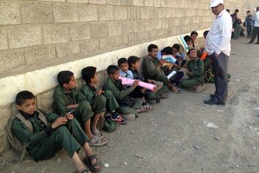 Yemeni children sit outside a school used by Houthi rebels. AFP 