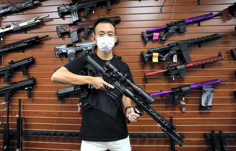 Tom Cai shows off a long gun at Jimmy's Sport Shop in Mineola, New York on September 25, 2020. - Gun store owners on Long Island have been selling out of firearms as scores of customers fear a rise in violence as the pandemic escalates in the area. (Photo by TIMOTHY A. CLARY / AFP)