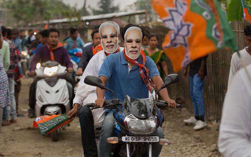 Bharatiya Janata Party supporters wearing masks of Indian Prime minister Narendra Modi, ride on motorbikes as they campaign ahead of general elections in Borhola village in Jorhat, Assam state, India, Tuesday, April 2, 2019. (AP Photo/Anupam Nath)