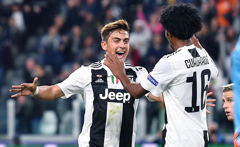 epa07064671 Juventus Paulo Dybala (L) celebrates with teammate Juan Cuadrado after scoring a goal during the UEFA Champions League group stage match between Juventus FC and BSC Young Boys Bern at the Allianz Arena in Turin, Italy, 02 October 2018.  EPA/ALESSANDRO DI MARCO