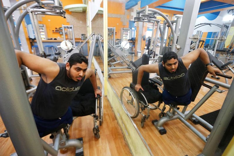Moamen Qreiqea is reflected in a mirror as he exercises in a gym.