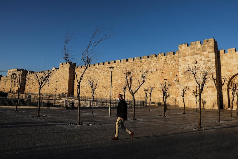 epa08931670 A man walks past at Jaffa Gate during a full lockdown in Jerusalem, Israel, 11 January 2021. Although Israel is one of the first countries to have received vaccines and has so far vaccinated almost two million of its around nine million citizens, the rate of infection with the Sars-CoV-2 coronavirus is rising drastically and Israel enter a full closure of two weeks.  EPA/ABIR SULTAN