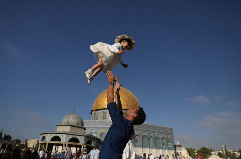 A Palestinian man throws his child in the air following morning prayers marking the first day of Eid al-Adha celebrations, on the compound known to Muslims as al-Haram al-Sharif and to Jews as Temple Mount in Jerusalem's Old City. Reuters