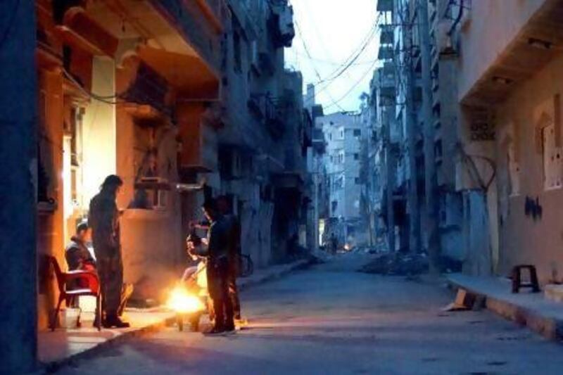 Members of the Free Syrian Army stand around a fire while they guard a neighbourhood in Deir Al Zor. Khalil Ashawi / Reuters