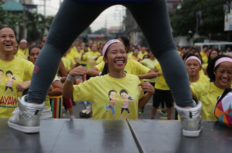 Filipinos smile while they follow steps during a Zumba class in an attempt to break a Guinness world record in suburban Mandaluyong, east of Manila, Philippines on Sunday, July 19, 2015.  Guinness representative Alan Pixley announced that Mandaluyong city in the Philippines now holds the new world record for the title largest Zumba class with a total participant of 12,975. Aaron Favila / AP photo