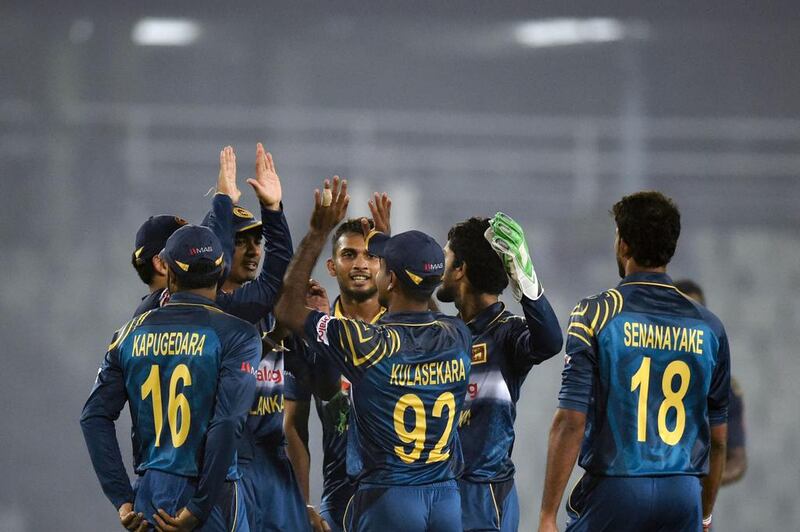 Sri Lanka players celebrate after the dismissal of India’s Suresh Raina during the Asia Cup T20 cricket tournament match between India and Sri Lanka at the Sher-e-Bangla National Cricket Stadium in Dhaka on March 1, 2016. / AFP / MUNIR UZ ZAMAN