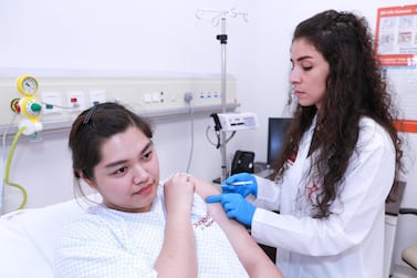 Dr Safaa Malkat injects a flu vaccine to a patient at Burjeel day centre on Reem Island. Young and old people are encouraged to get the vaccine, as are people with underlying medical conditions. Victor Besa / The National
