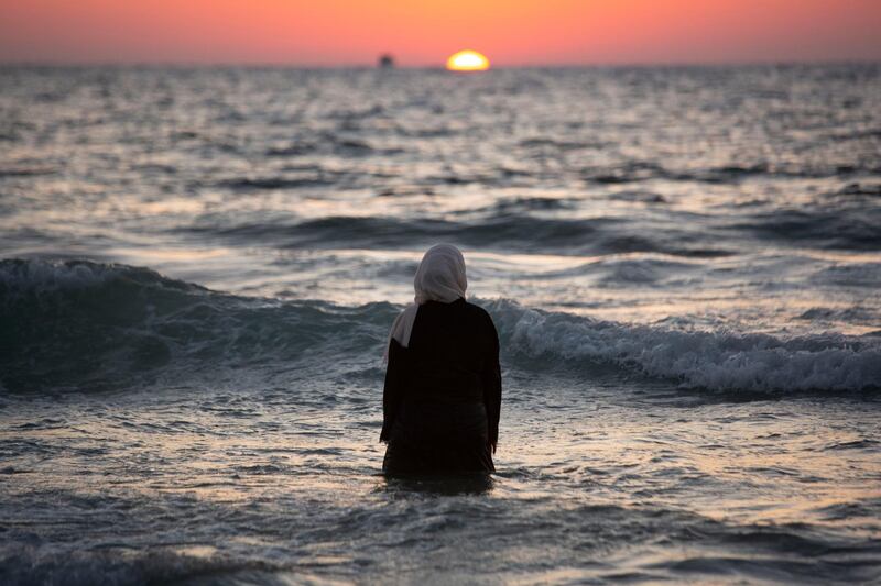 A Palestinian woman enjoys the day on the beach during the Eid Al Adha festival in Tel Aviv Israel.  AP