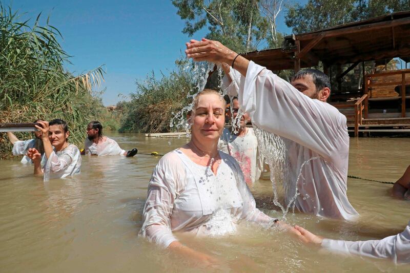 Christian pilgrims are baptised by a priest in the waters of the Jordan River at a site known as Qasr al-Yahud near the West Bank town of Jericho. AFP