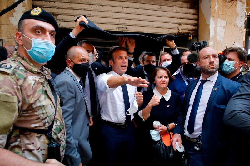 French President Emmanuel Macron gestures as he visits a devastated street of Beirut, Lebanon, on August 6, 2020 a day after a massive explosion devastated the Lebanese capital in a disaster that has sparked grief and fury. French President Emmanuel Macron visited shell-shocked Beirut Thursday, pledging support and urging change after a massive explosion devastated the Lebanese capital in a disaster that has sparked grief and fury. / AFP / POOL / Thibault Camus
