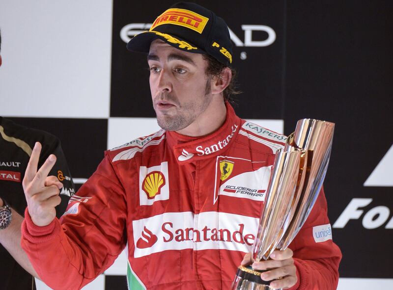 Ferrari's Spanish driver Fernando Alonso  celebrates on the podium at the Yas Marina circuit on November 4, 2012 in Abu Dhabi after the Abu Dhabi Formula One Grand Prix. AFP PHOTO / DIMITAR DILKOFF
 *** Local Caption ***  818817-01-08.jpg