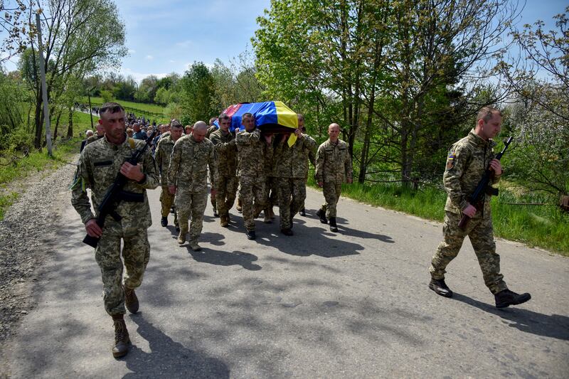 Ukrainian servicemen carry the coffin of a killed soldier, one of many who have died in the conflict with Russia. Reuters