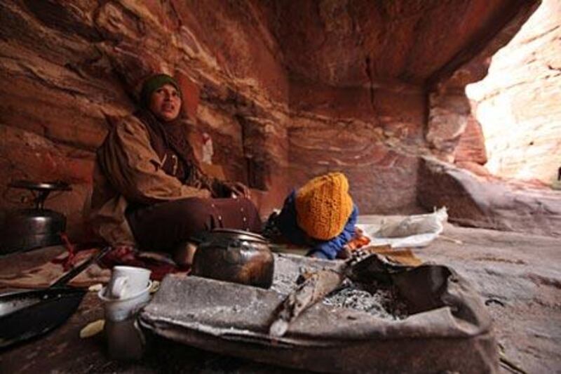 A Bdoul Bedouin, Um Mohammed and her daughter Yasmine, sit in their cave in Petra, Jordan. Many former inhabitants have been promised land to build houses by the government but have yet to receive it.
