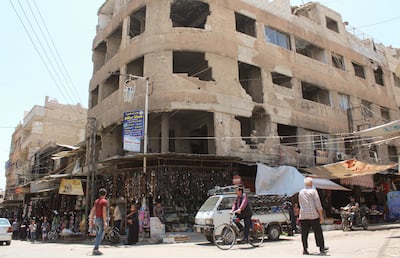People walk near shops in Douma, Syria June 19, 2023. Reuters