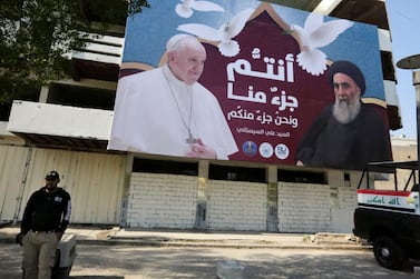 A giant billboard bears portraits of Pope Francis and Grand Ayatollah Ali Sistani in Baghdad on March 3, 2021. AFP