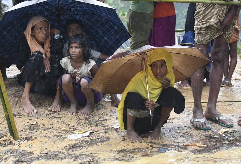 (FILES) In this file photo taken on September 17, 2017 Rohingya refugees protect themselves from rain in Balukhali refugee camp near the Bangladesh town of Gumdhum.
Humanitarian agencies have been warning for months about the danger posed by the impending 2018 monsoon, due to start in June, to the welfare of refugees who live cheek by jowl in cramped tents on hillsides, following a mass exodus from Myanmar in 2017.
 / AFP PHOTO / DOMINIQUE FAGET