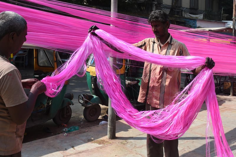 Workers dry out coloured polyster/silk yarn from which garlands are made ahead of the Hindu festival of Diwali in Ahmedabad on October 17, 2019. Colourful garlands are in demand during the Hindu festival of Diwali, or Festival of Lights, which falls on October 27 this year. AFP
