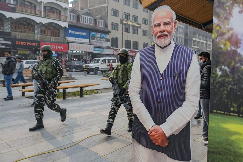 Troops patrol past a cut-out of India's Prime Minister Narendra Modi in Srinagar, Kashmir, as security was increased before the Supreme Court verdict. AFP