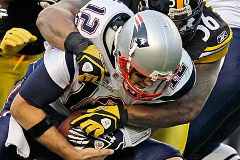 Tom Brady, front, did not see much of the ball against the Pittsburgh Steelers as the linebacker, LaMarr Woodley, sacks the quarterback in the fourth quarter.