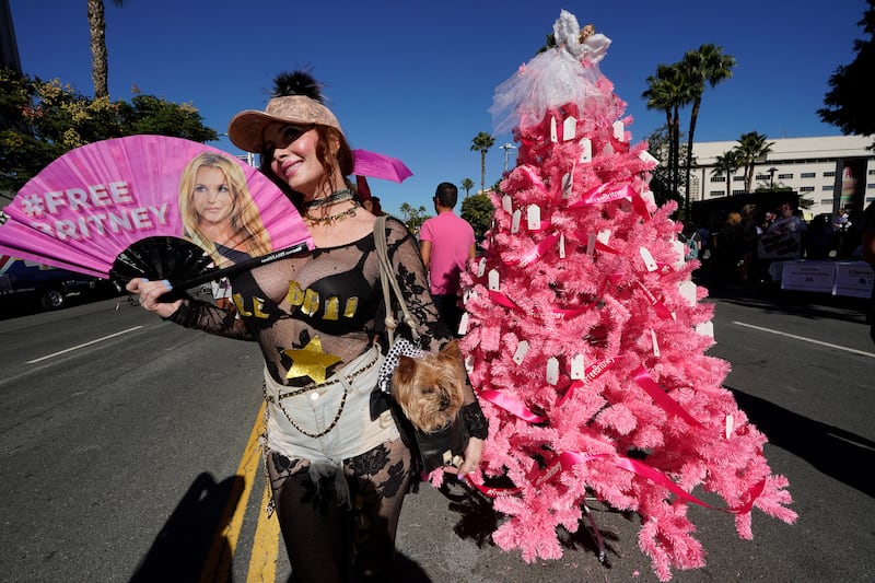 Britney Spears supporter Phoebe Price and her dog Henry take pictures next to a 'Free Britney' Christmas tree set by fans outside the courthouse. AP