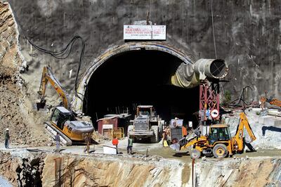 Rescue workers stand at an entrance of the under construction road tunnel, days after it collapsed. AFP