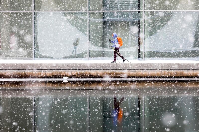 A person uses cross-country skis during heavy snowfall alongside the river Spree through the government district in Berlin, Germany. AP Photo