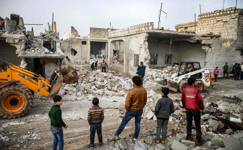 Members of the Syrian Civil Defence (also known as "The White Helmets"), use a bulldozer to remove debris from buildings which were damaged by reported air strikes in the rebel-held town of Orum al-Kubra, in the northern Syrian province of Aleppo, on January 5, 2019. Airstrikes by Syrian regime ally Russia hit the west of Aleppo province late on January 4, the first such raids in the area since a deal between Moscow and rebel backer Ankara to stave off a massive regime offensive on the wider Idlib region in September 2018. / AFP / Aaref WATAD
