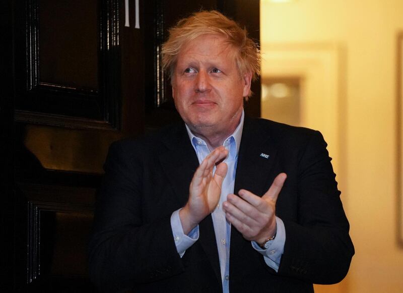 A handout image released by 10 Downing Street, shows Britain's Prime Minister Boris Johnson as he participates in a national "clap for carers" to show thanks for the work of Britain's National Health Service (NHS) workers and frontline medical staff around the country as they battle with the novel coronavirus pandemic, in the doorway of 10 Downing Street in central London on April 2, 2020. - ˜The UK government said Friday it was rushing to build more emergency field hospitals ahead of an expected surge in coronavirus cases, hours after recording a record 569 deaths from the disease. (Photo by Pippa FOWLES / 10 Downing Street / AFP) / RESTRICTED TO EDITORIAL USE - MANDATORY CREDIT "AFP PHOTO / 10 DOWNING STREET / PIPPA FOWLES" - NO MARKETING - NO ADVERTISING CAMPAIGNS - DISTRIBUTED AS A SERVICE TO CLIENTS