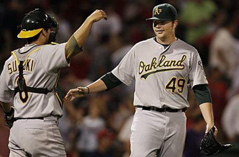 Oakland Athletics starting pitcher Brett Anderson, right, is congratulated by catcher Kurt Suzuki after Anderson pitched a two-hitter in Oakland's 6-0 win over the Boston Red Sox.